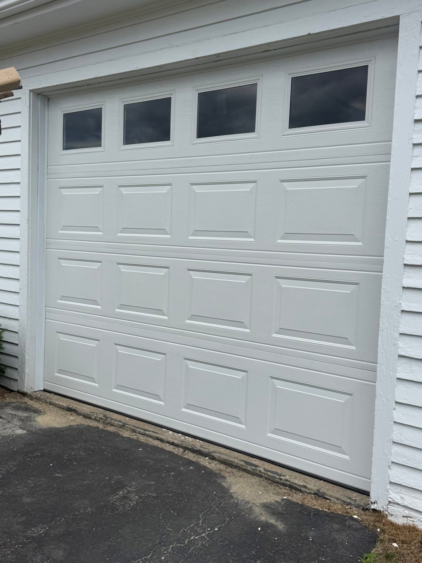 New insulated white steel garage door with window inserts installed